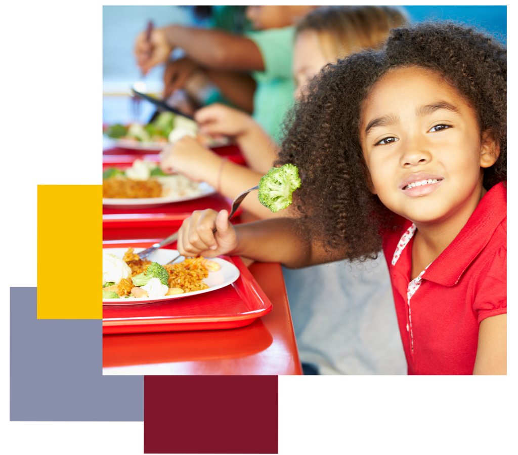 Kid holding fork with broccoli sitting at lunch table. Project L.E.A.P child care summer food service program